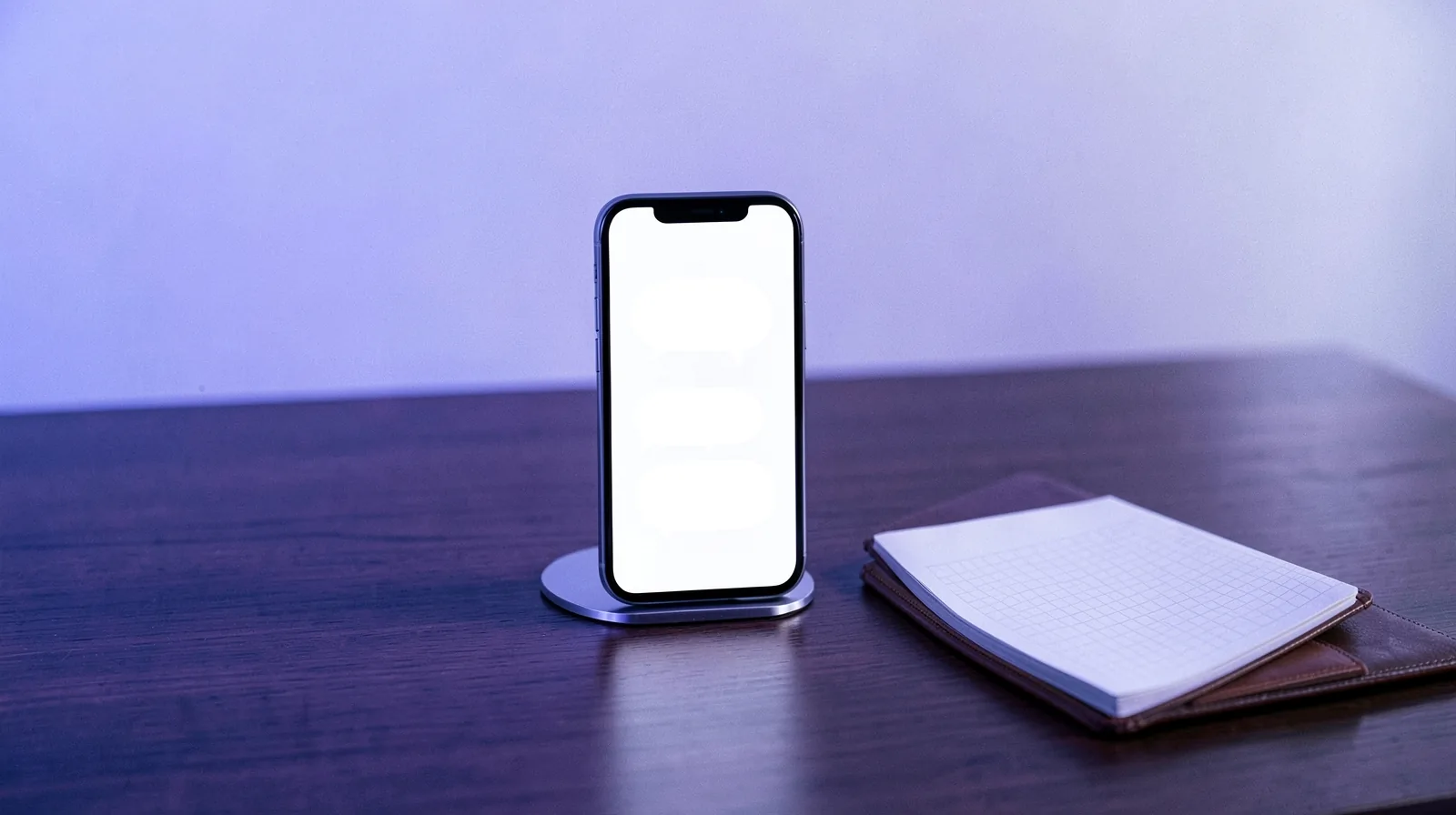 Celular num suporte com tela de conversa e bloco de anotações aberto numa mesa de atendimento