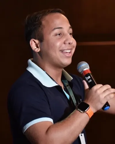Lucas Lacerda falando ao microfone em um evento